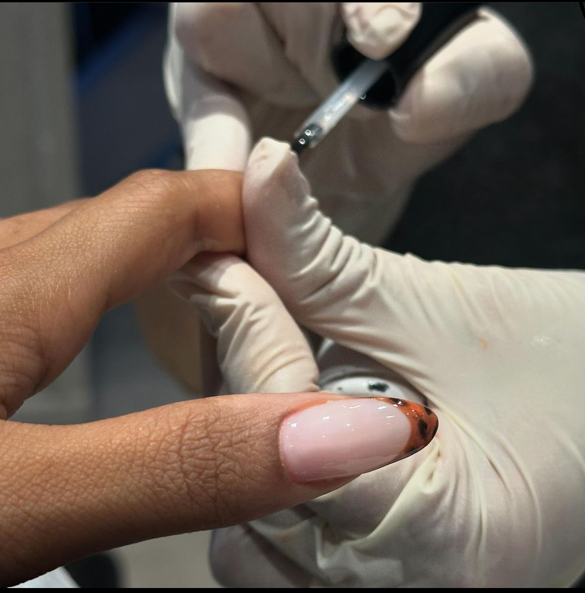A close-up of a hand getting nail polish applied at Bedashing Beauty Lounge.