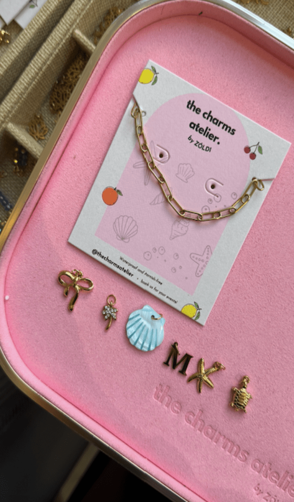 Hands carefully crafting a personalized charm at a workshop, engraving intricate designs onto a small metal pendant.
