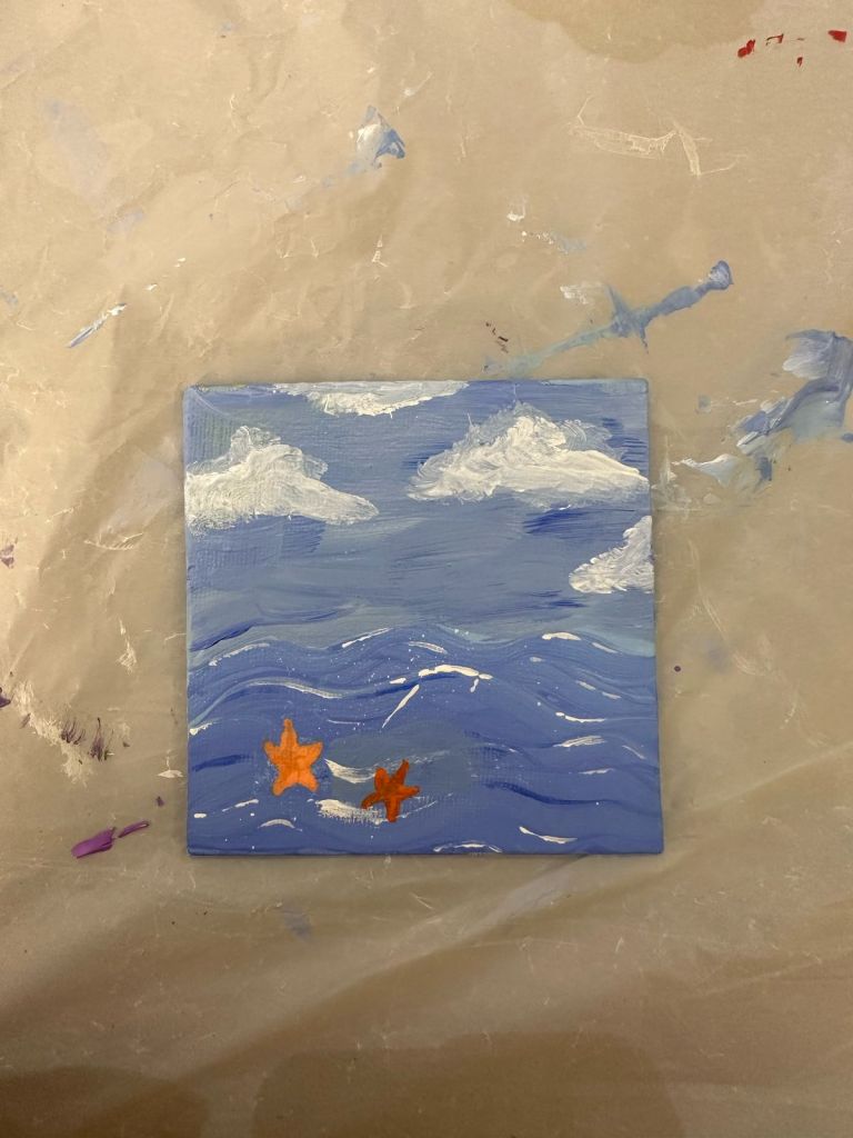 Blue painting of a seascape with starfish and clouds. 
