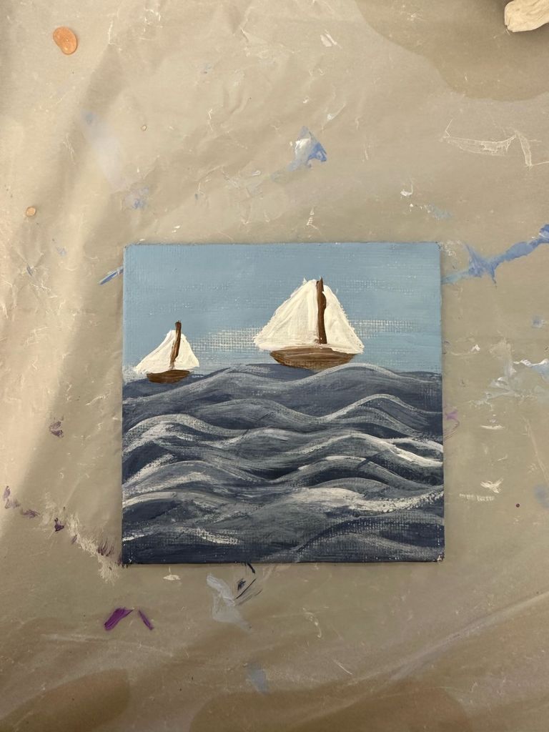 Hand-painted canvas of sailboats on a wavy ocean scene.
